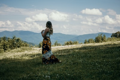 Standing in the mountains green grass oriented woman
